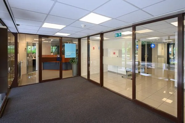 Ingang van het kantoor van Jeugdbescherming Rotterdam Rijnmond met balie en wachtruimte.